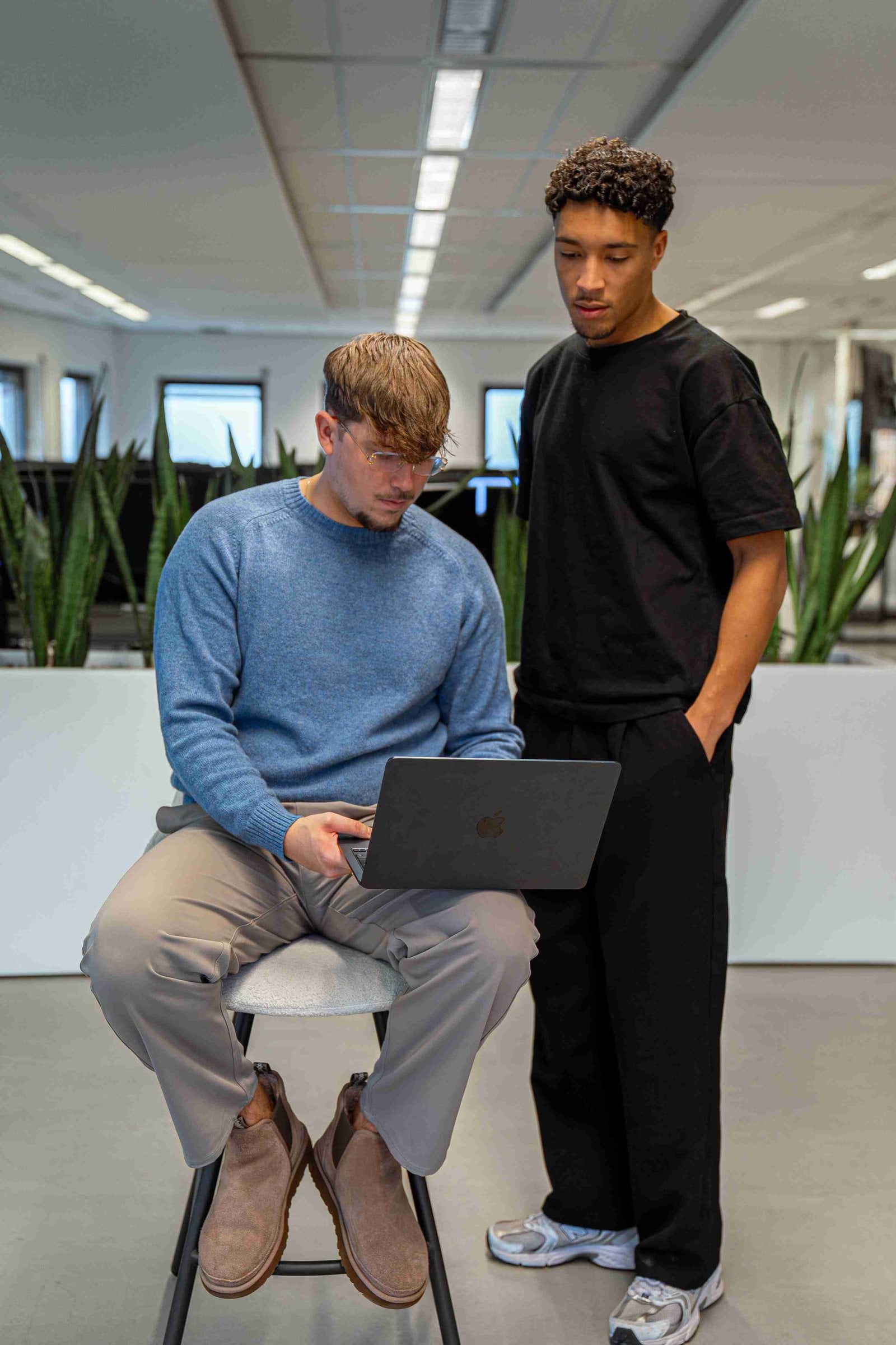 Pepijn en Leon werken samen aan een laptop bij De Netwerqer